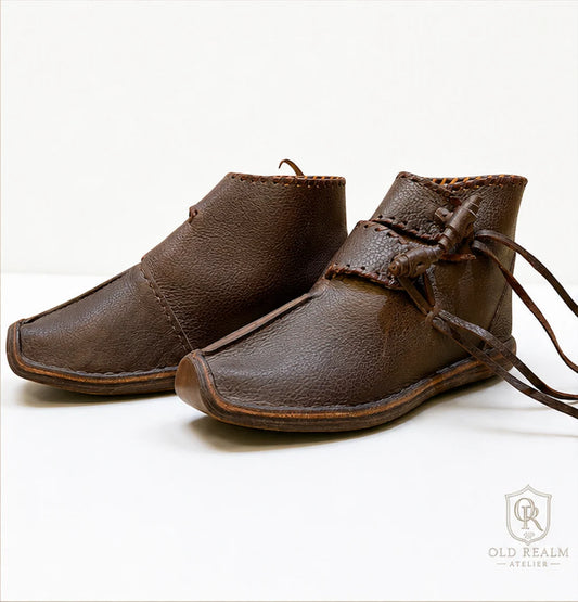 Medieval Shoes for Historical Reenactment: What to Look For - brown handmade leather boots with lacing and rounded toe.