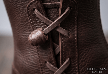 Close-up of handcrafted brown LARP boots with leather texture, laces, and toggle for Fantasy Boots for LARP & Medieval Cosplay.