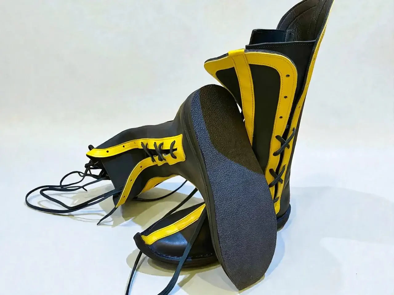 Black and yellow handmade medieval leather boots with wrap laces and full-grain texture, ideal for LARP or Renaissance faire